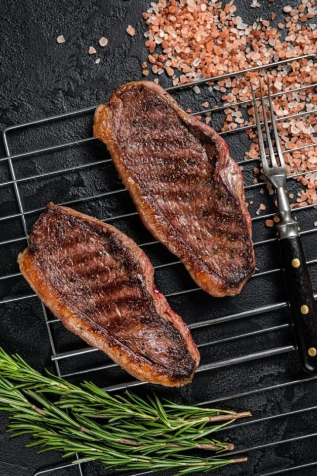 Two Steaks on Grill with Herbs